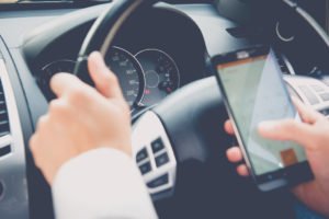 man texting while driving in a car in Kentucky