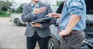Men discussing insurance claims after car accident