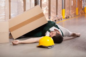 a warehouse worker fell on the floor after he was hit by a heavy box - warehouse hazards