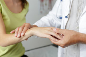 a doctor checking a woman's hand with carpal tunnel syndrome