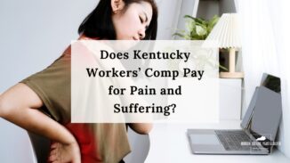 woman sitting at desk holds her shoulder in pain with her other hand on her lower back
