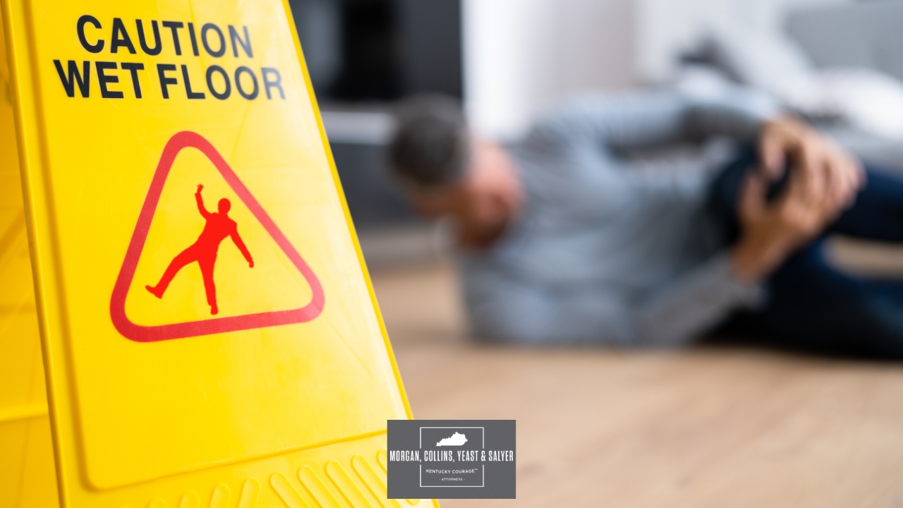 injured person behind slippery surface sign