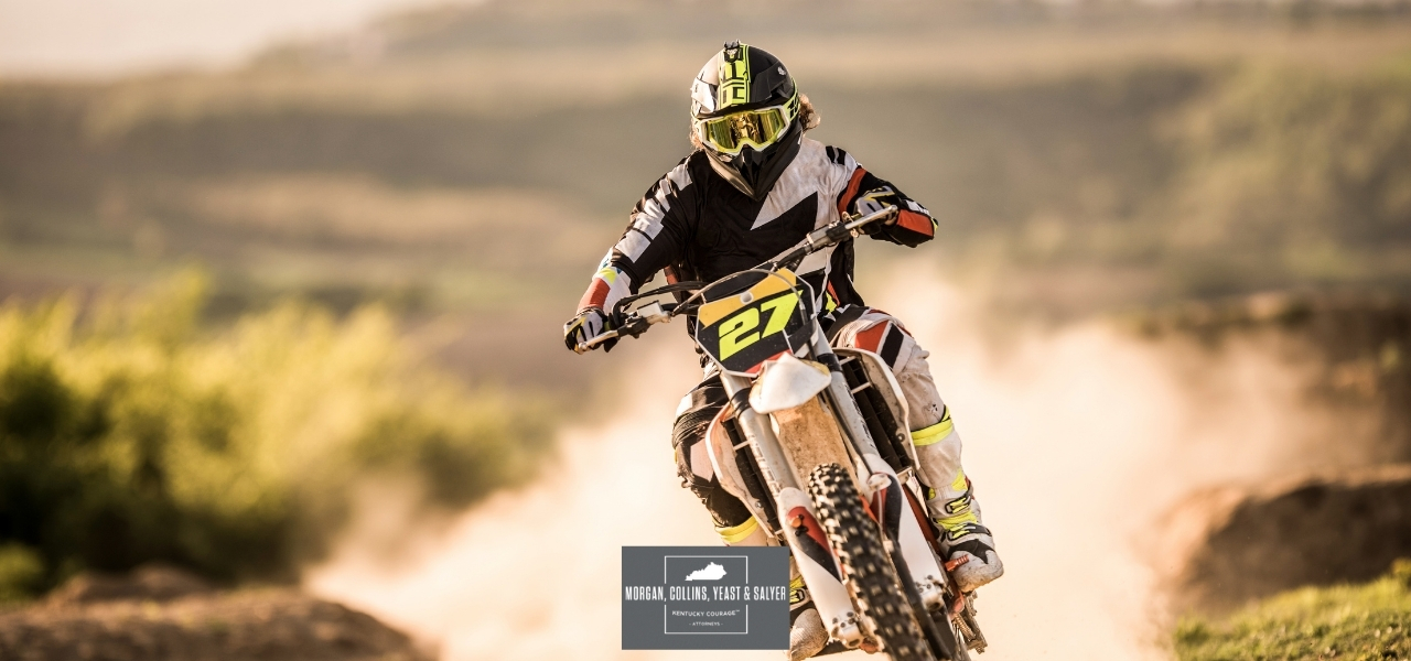 a dirt bike riding past a trail of dust